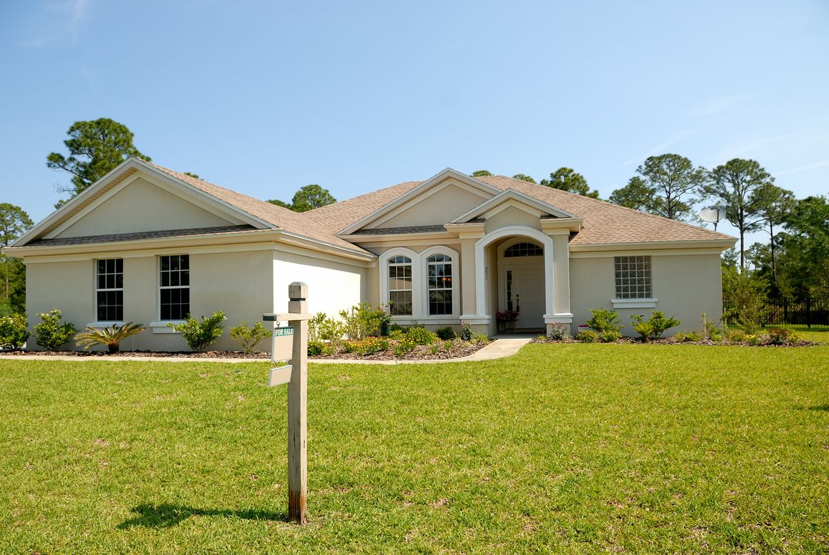 Residential house with a For Sale sign, representing a property available for financing